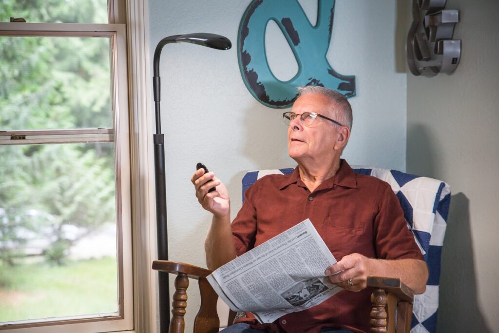 Man reading newspaper using Stella light.